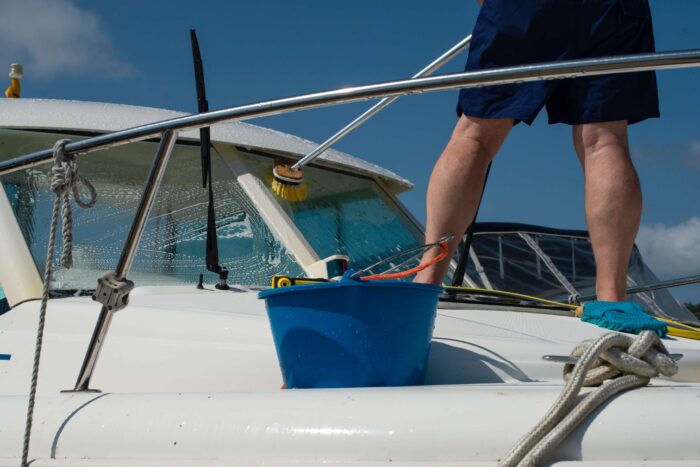 Man washing the front of yacht